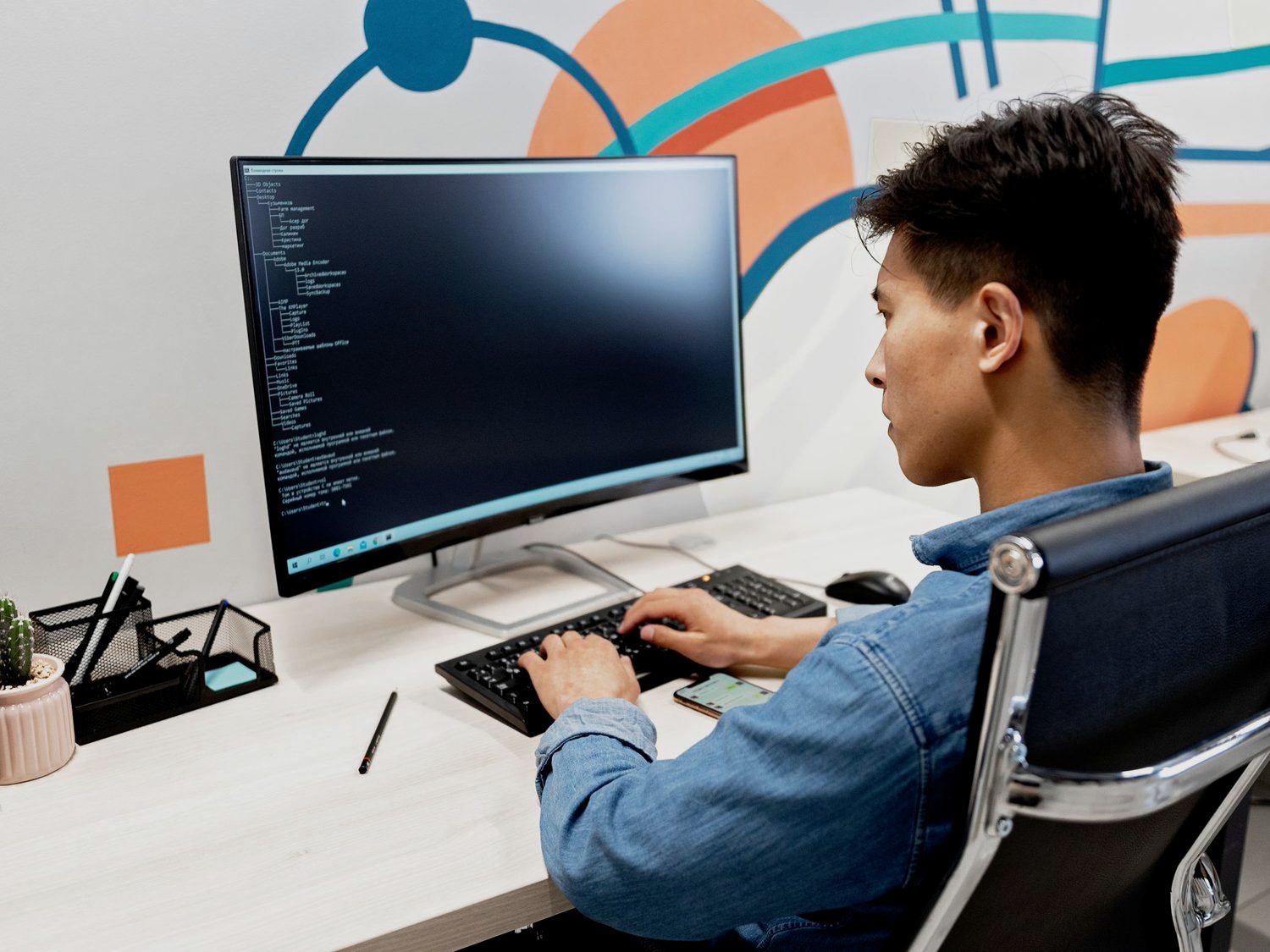 A developer writing code at a desk